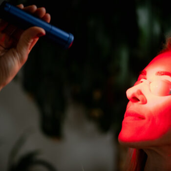 Woman Using Red Light Therapy During A Skincare Session, Known For Boosting Collagen, Reducing Wrinkles, And Improving Skin Tone With Non Invasive Led Light Treatment.
