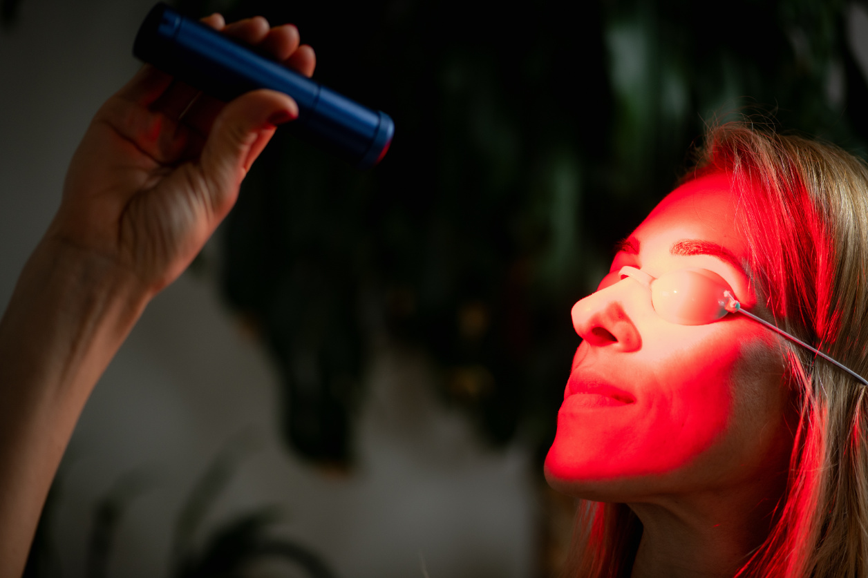 Woman Using Red Light Therapy During A Skincare Session, Known For Boosting Collagen, Reducing Wrinkles, And Improving Skin Tone With Non Invasive Led Light Treatment.